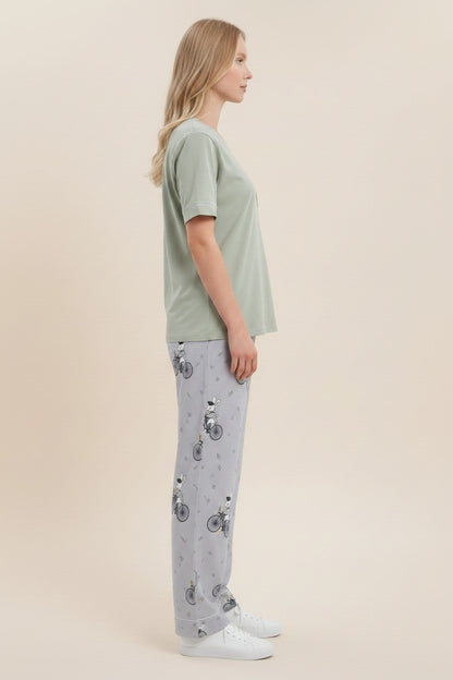 pyjama olive cotton t-shirt and grey patterned lounge pants worn by a woman in a side profile view