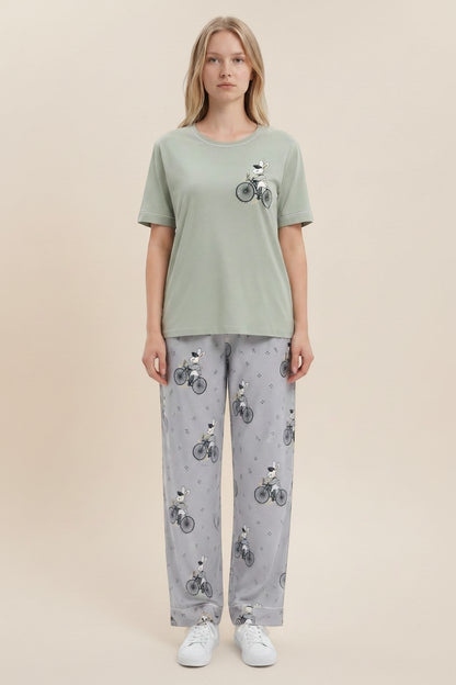 pyjama olive cotton pyjama set with rabbit on bicycle print worn by a blonde model against a neutral background